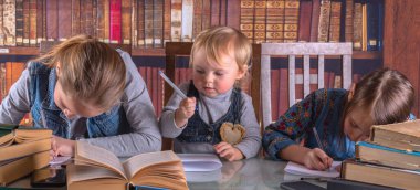 Kavramsal görüntü: çocuk gelişimi ve erken öğrenme. Genç bilim adamları kütüphanede çalışır ve kitap okurlar. Yatay resim.