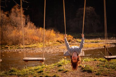 Çocukların uçabilme hayalleri. Salıncakta baş aşağı duran güzel bir genç kızın portresi. Mutlu çocukluk, özgürlük kavramı. 
