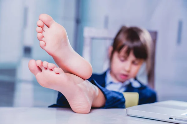 一个幽默的形象是 一个快乐的高加索女孩脱下鞋子 赤着脚在办公室里工作 对赤脚的选择性关注 图库图片
