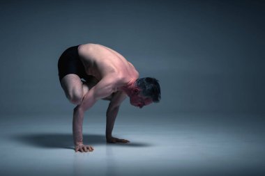 Bakasana, Ashtanga 'da yoga yaparken spor giyimli bir adamın yoga manzarası. Metin veya tasarım için boşluk kopyala. 