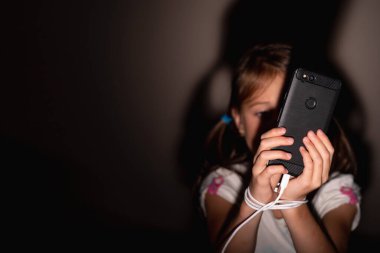 Geceleri genç bir kızın portresi internette yayınlanıyor. Çocuk oyuncağı bağımlılığı ve uykusuzluk. İnternet bağımlılığının yan etkileri olarak anksiyete ve uykusuzluk. Portre. Yatay resim.