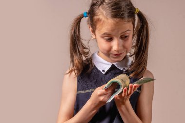 Kavramsal görüntü: Para çocukların davranışlarını etkiler, değerini anlamasalar bile. Avro parasını elinde tutan genç ve güzel bir kız. Uzayı kopyala Yatay resim.