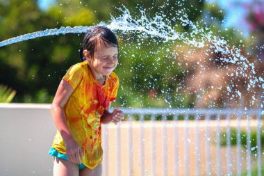 Su parkındaki bir su deresinin altında çok mutlu bir genç kızın portresi. Yaz su parkı ve tatil konsepti. Metin veya tasarım için boşluk kopyala.