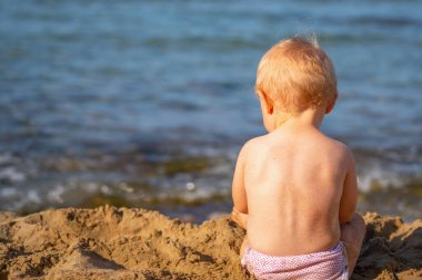 Küçük bebek portresi sahilde kumsalda oynar yaz tatili, dinlenme, tatil, insanlar, neşe, mutluluk konsepti. Yatay görüntü. Metin veya tasarım için boşluk kopyala.
