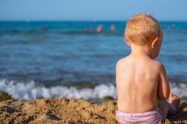 Küçük bebek sahilde kumsalda oynar yaz tatili, dinlenme, tatil, insanlar, neşe, mutluluk konsepti. Boşluğu kopyala.