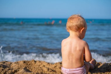 Küçük bebek kumsalda oynuyor yaz tatili, dinlenme, tatil, insanlar, neşe, mutluluk konsepti..