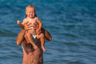 Baba, bebekle birlikte denizde yüzüyor. Doğa, seyahat, okyanusta oynayan mutlu baba ve çocuk.