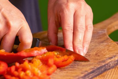 İtalyan ekmeği ve malzemeleri - parmesan, zeytinyağı, domates, baharat ve bitkiler. Şefin ellerini kapayın, pizzada kırmızı biber dilimleri kesin. Seçici odak.