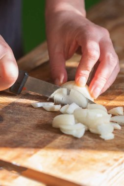 İtalyan ekmeği ve malzemeleri - parmesan, zeytinyağı, domates, baharat ve bitkiler. Şefin ellerini kapayın, pizzada kırmızı biber dilimleri kesin. Dikey resim.