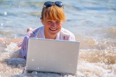 Very happy business woman working anywhere and anytime. She working online with laptop on the beach of sea or ocean. Copy space. clipart
