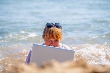 Work anywhere and anytime. Portraiit of very happy business woman is happy to work online with laptop on the beach of sea or ocean. Horizontal image. clipart