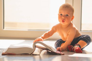 Kitabı okuyan tatlı bebek. Metin ya da tasarım için uzayı kopyala... yatay resim. Çocuk gelişimi konsepti. Boşluğu kopyala.
