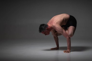 Bakasana, Ashtanga yogası spor giysili bir adamın karanlık arka planda yoga yaparken görüntüsü.. 