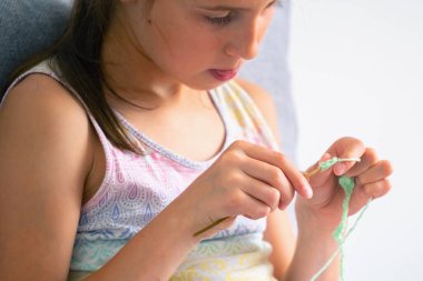 Özel ev kullanımı için iplik ören genç bir kız. Yatay resim.