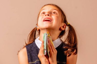 Para çocukların davranışlarını etkiler. Avro parasını elinde tutan mutlu genç bir kızın portresi.. 