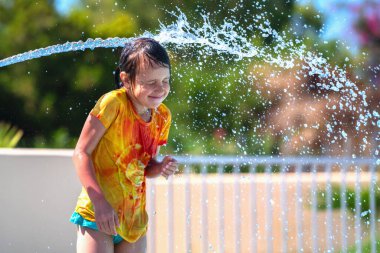 Su parkındaki bir su deresinin altında çok mutlu bir genç kızın portresi. Yaz su parkı ve tatil konsepti. Metin veya tasarım için boşluk kopyala.
