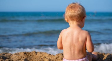 Küçük bebek sahilde kumsalda oynar yaz tatili, dinlenme, tatil, insanlar, neşe, mutluluk konsepti. Metin veya tasarım için boşluk kopyala.