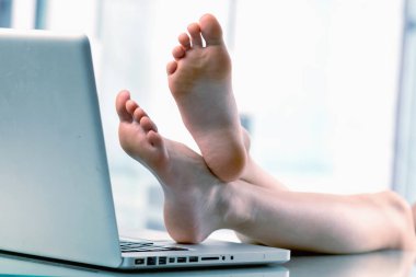 Bugün çalışmak için havamda değilim. Genç iş kızı dizüstü bilgisayarın başına çıplak ayakla geçti, ofiste çalışmak istemiyor.. 