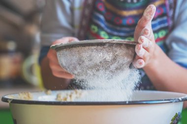 Genç bayan aşçı elleri hamur yoğuruyor, üzerine beyaz buğday unu serpiyor. Yemek, yemek pişirme ve el yapımı konsept sanatı. Yatay görüntü. Seçici odak.