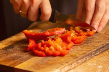 İtalyan ekmeği ve malzemeleri - parmesan, zeytinyağı, domates, baharat ve bitkiler. Şefin ellerini kapat. Pizzada kırmızı biber dilimleri kes.. 