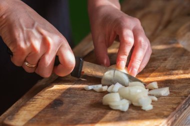 İtalyan ekmeği ve malzemeleri - parmesan, zeytinyağı, domates, baharat ve bitkiler. Şefin elleri pizzada kırmızı biber dilimleri kesiyor.. 
