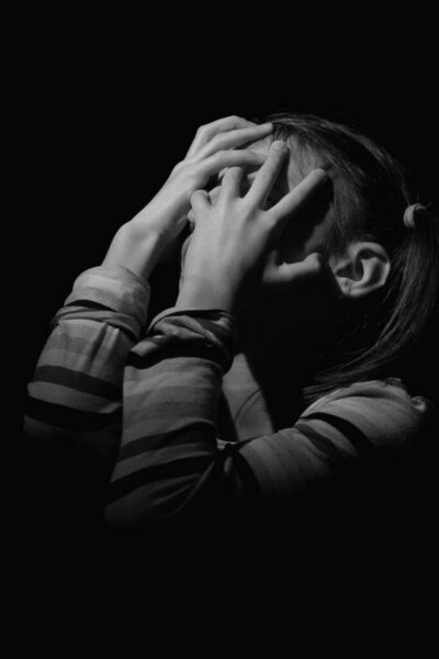 Depressed and sad girl with scream in mental and psychic pain, crying from loneliness. Anxiety, stress, loneliness and abandonment concept. Black and white image. Vertical image.