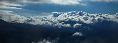 Dağ sırasının zirvelerinde dramatik bulutlar ve nebula manzarası. Gökyüzü ve yeryüzü arasında. Güzel doğa konsepti.