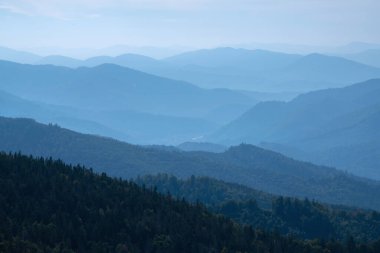 Rocky deep gorge with sharp sheer crags silhouettes against blue sky.  clipart