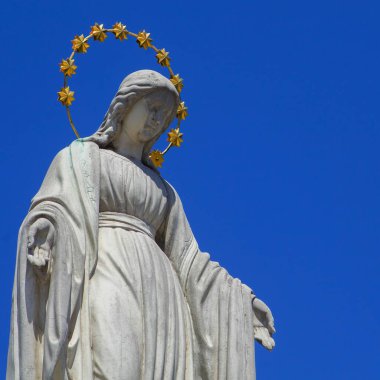 Cennetin kraliçesi Bakire Meryem mavi gökyüzüne karşı.. Boşluğu kopyala.