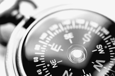 Seyahatin sembolü olarak pusula görüntüsü ve doğru yönde hareket etmek. Siyah ve beyaz resim.