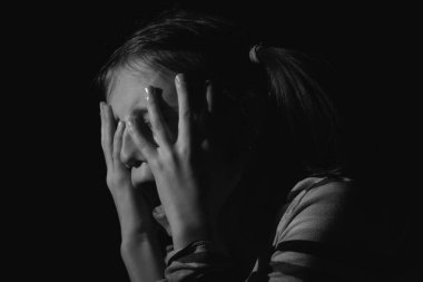 Stresli, mutsuz ergen kız ağlıyor ve yorgun ya da depresif hissediyor. Yatay siyah beyaz resim. 