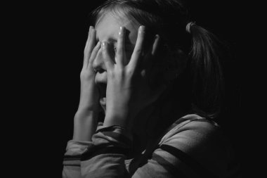 Stresli, mutsuz ergen kız ağlıyor ve yorgun ya da depresif hissediyor. Siyah ve beyaz resim. 