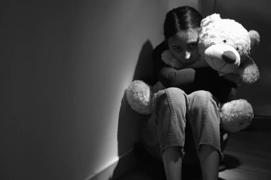 Kavramsal görüntü: Ergenlerin duygusal ve davranışsal sorunları. Yalnız ve üzgün genç kız tek arkadaşına sarılıyor, oyuncak bir ayıya. Siyah beyaz portre. Boşluğu kopyala 