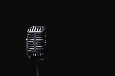 Siyah arka plana karşı eski moda bir mikrofon. Metin veya tasarım için boşluk kopyala. 