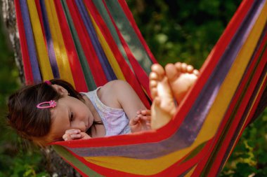 Hamakta yatan üzgün, genç, güzel kız.