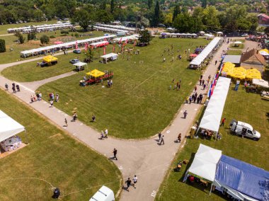 5 Haziran 2022 'de. - TEMERIN, SERBIA: Sırbistan 'ın Temerin kentinde 5 Haziran 2022' de Sırbistan 'da düzenlenen Pasuljijada Bean Festivali 2022 Gıda ve Müzik Festivali Sahneleri. İnsanlar güzel bir yaz gününün tadını çıkarırken, geleneksel yemek ve içecekler DJ ve müzik B