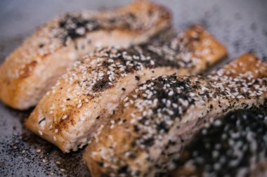 Susamlı ızgara somon dilimleri, baharat ve parşömen kağıdında pişirmek için bitkiler.