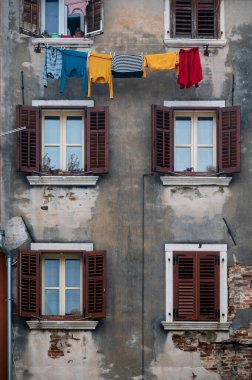 Çamaşırlar renkli cephelerde asılı, Rovinj 'deki antik Akdeniz binaları, Hırvat kıyısındaki eski kasaba. Eski Venedik evi duvarı ve açık havada kuruyan elbiseler..