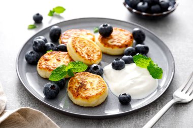 Kahvaltı için taze yaban mersinli ve yoğurtlu süzme peynirli börek.