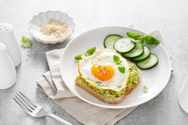 Kahvaltıda kızarmış yumurtalı avokado tostu, sağlıklı yemek.