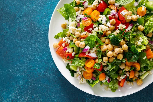 Stock image Tabbouleh salad. Tabouli salad with fresh parsley, onions, tomatoes, bulgur and chickpea. Healthy vegetarian food, diet. Top view