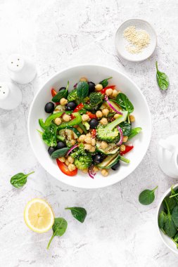 Chickpea and spinach vegan vegetable salad with broccoli, sweet pepper, olives and grilled zucchini. Mediterranean diet, healthy food. Top view clipart