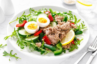 Salad with canned tuna, boiled egg, arugula and fresh vegetables