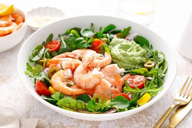 Shrimp and leafy vegetables salad with tomato, bell pepper, olive and avocado sauce