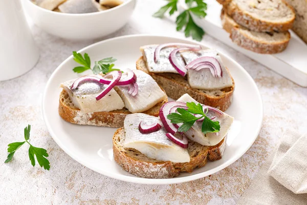 Herring sandwich. Open sandwiches with whole grain bread, herring and onion