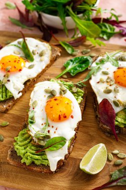 Egg and avocado toast, sandwiches with eggs and fresh greens. Healthy diet food