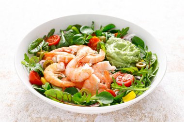 Shrimp and leafy vegetables salad with tomato, bell pepper, olive and avocado sauce