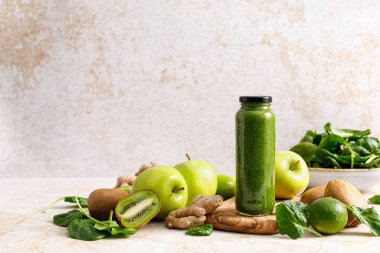 Smoothie. Healthy fresh raw detox spinach smoothie with green apple, kiwi and ginger in a bottles on a table. Healthy diet vegan food full of antioxidants