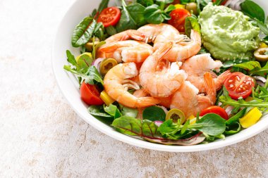 Shrimp and leafy vegetables salad with tomato, bell pepper, olive and avocado sauce