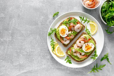 Karidesli tost, avokado guacomole, roka ve haşlanmış yumurta.